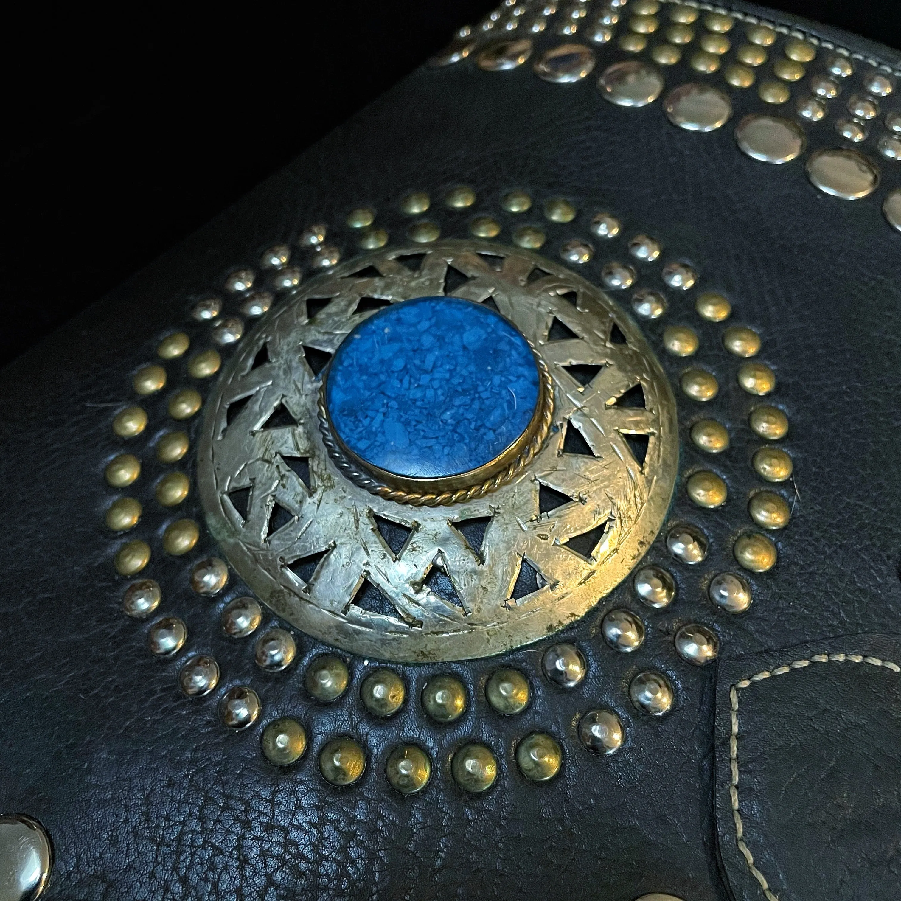 A HAND CRAFTED WESTERN STYLE STUDDED BAG WITH BLUE JEWEL