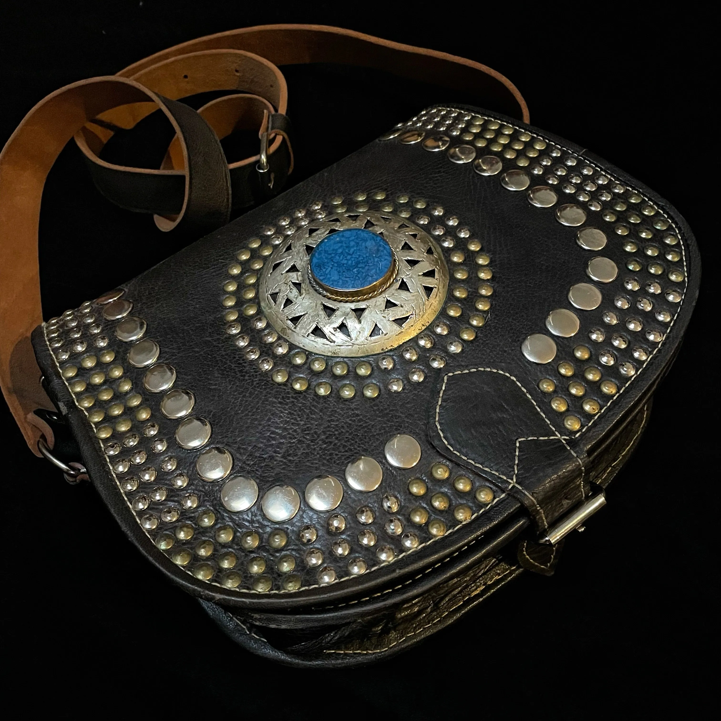 A HAND CRAFTED WESTERN STYLE STUDDED BAG WITH BLUE JEWEL